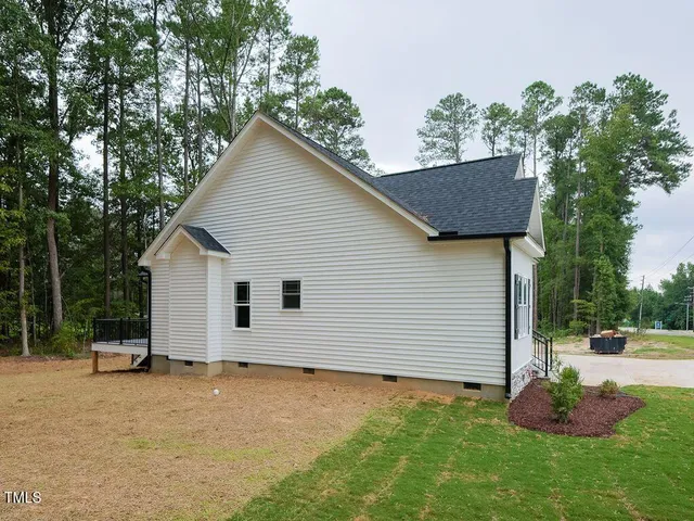 a view of backyard of house with wooden fence