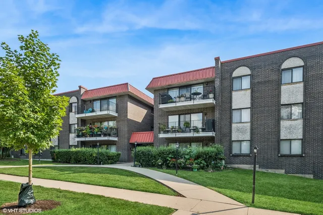 a front view of a residential apartment building with a yard