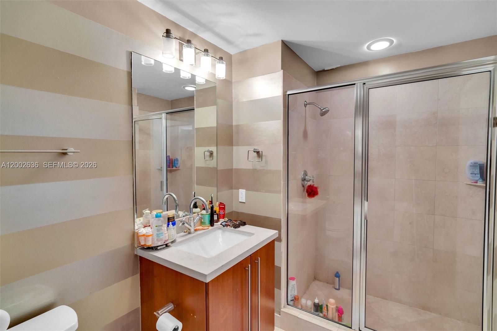 79 Southwest 12th Street, Unit 1605 Miami, FL 33130 - Photo 11 of 30 a bathroom with a sink vanity mirror and shower
