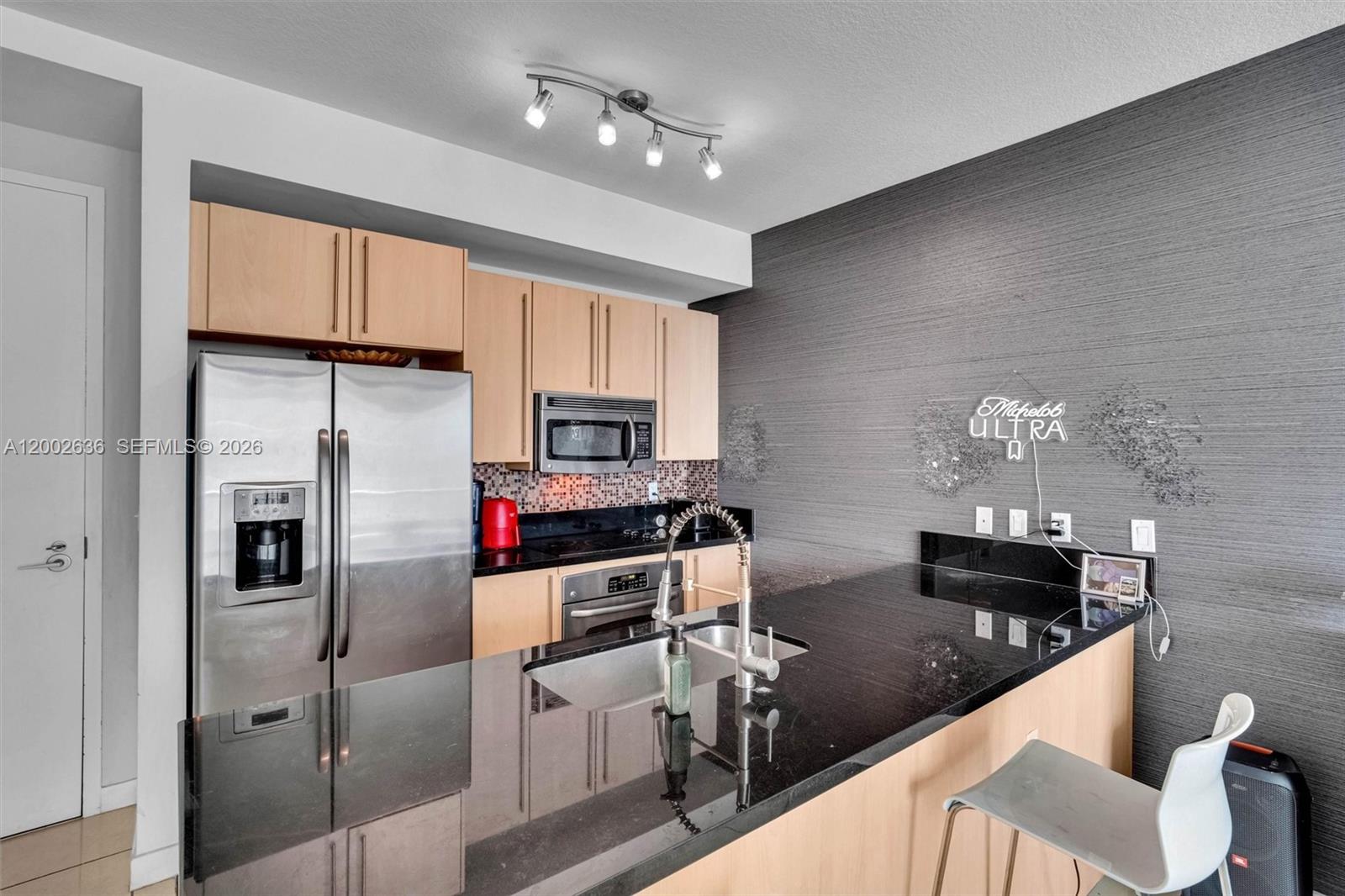 79 Southwest 12th Street, Unit 1605 Miami, FL 33130 - Photo 3 of 30 a kitchen with stainless steel appliances granite countertop a refrigerator and a stove top oven