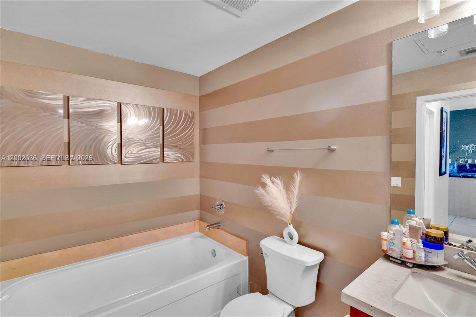 79 Southwest 12th Street, Unit 1605 Miami, FL 33130 - Photo 10 of 30 a bathroom with a tub sink mirror and toilet