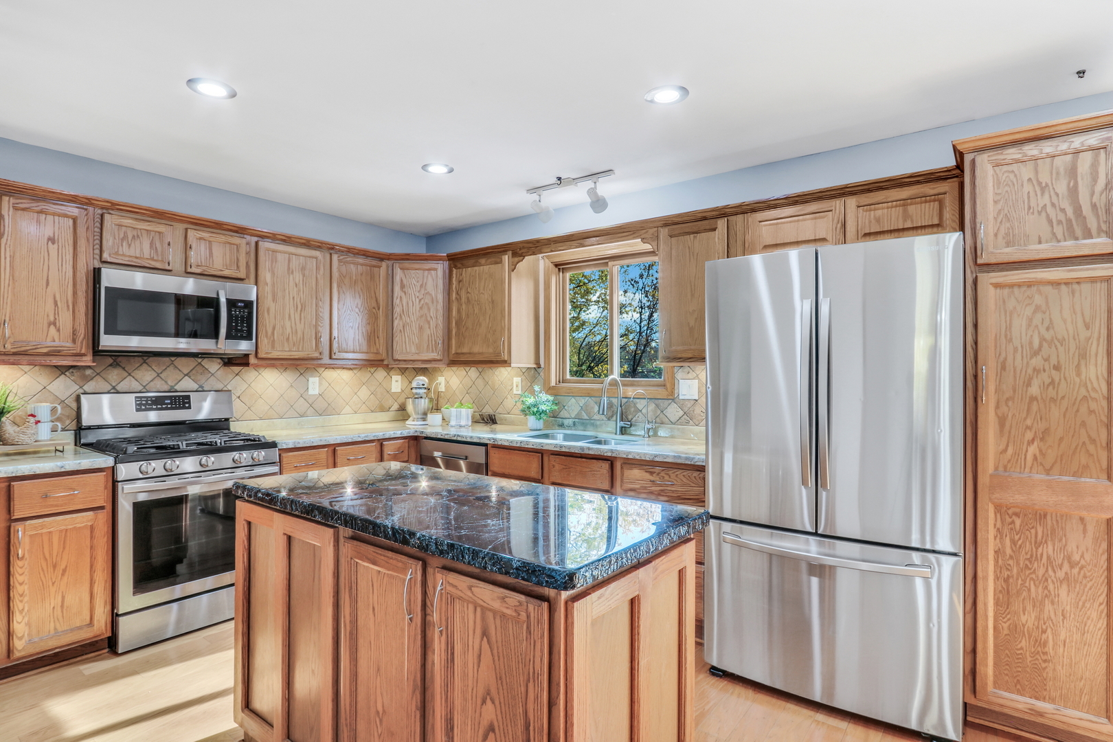 25911 West Highpoint Road Ingleside, IL 60041 - Photo 9 of 29 a kitchen with stainless steel appliances granite countertop a refrigerator a stove a sink a microwave a refrigerator and white cabinets with wooden floor