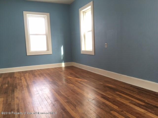 433 East 2nd Street Rifle, CO 81650 - Photo 7 of 8 a view of an empty room with wooden floor and a window