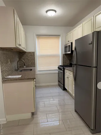 a kitchen with a refrigerator sink and cabinets