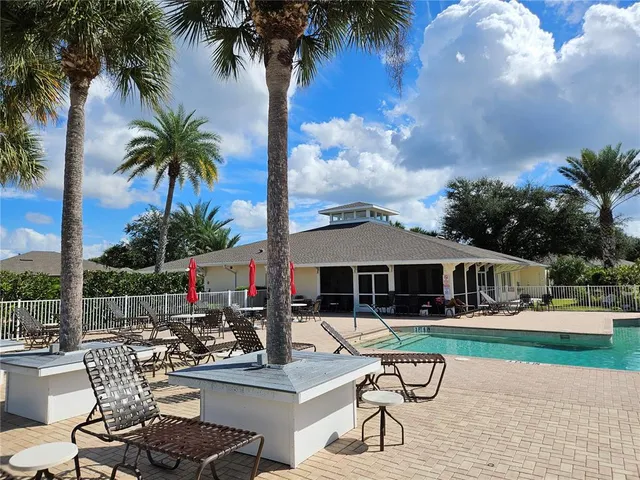 a view of a patio with table and chairs potted plants and palm tree