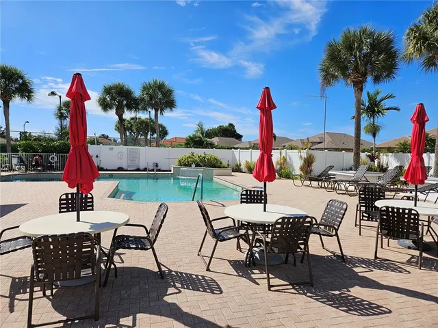 a view of a patio with table and chairs potted plants and palm tree