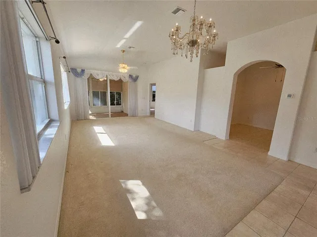 a view of a big room with chandelier and windows