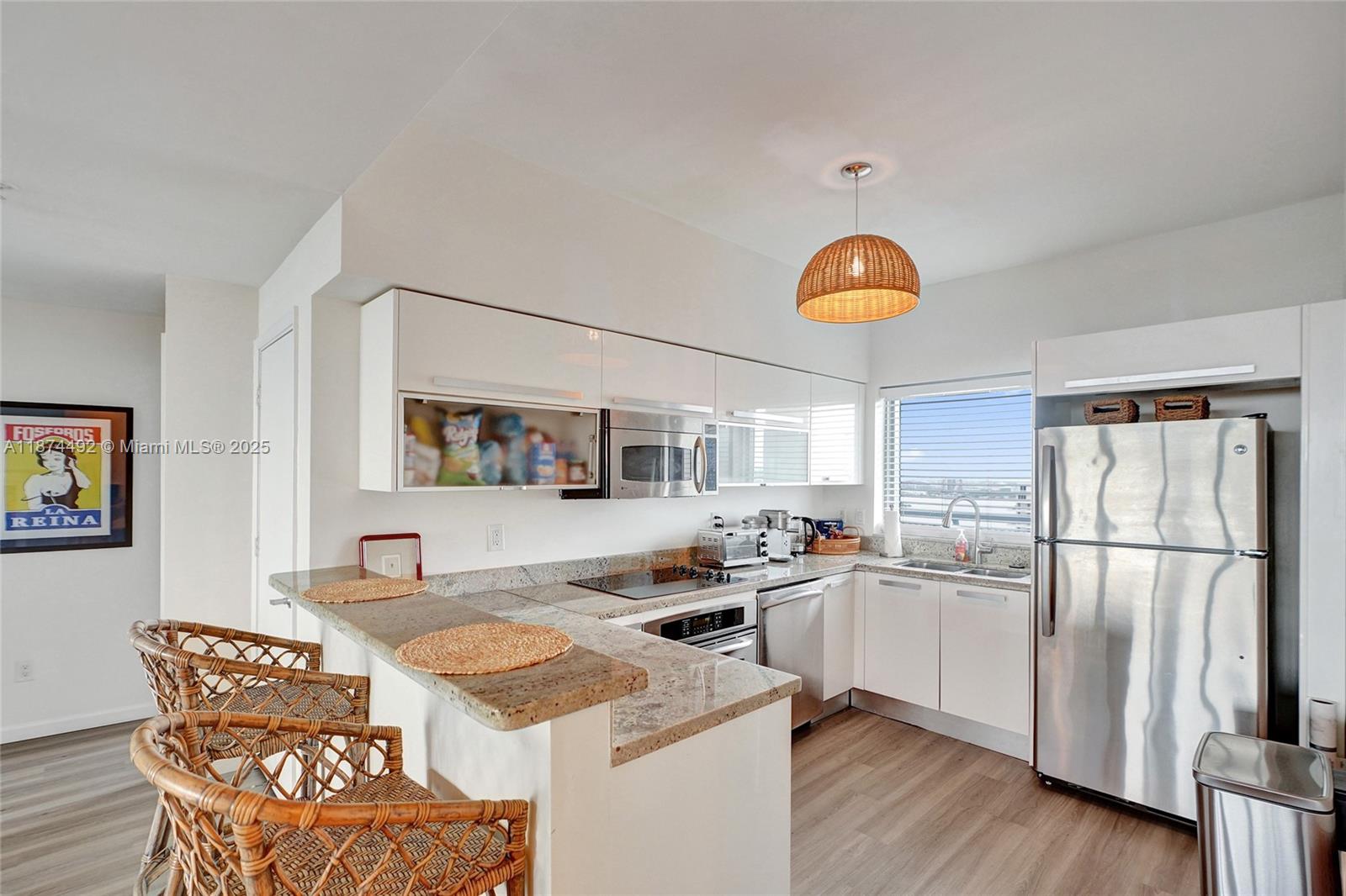 601 Northeast 36th Street, Unit 2703 Miami, FL 33137 - Photo 5 of 64 a kitchen with a refrigerator a stove a sink and a dining table with wooden floor