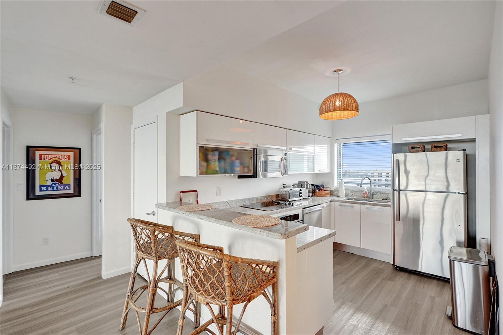 601 Northeast 36th Street, Unit 2703 Miami, FL 33137 - Photo 6 of 64 a kitchen with a refrigerator and a stove top oven