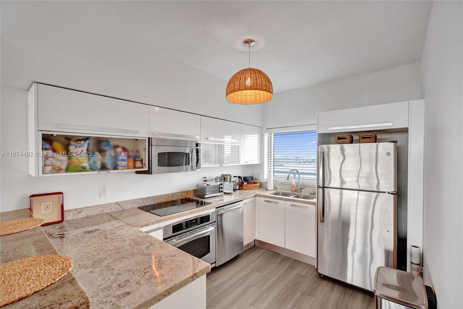 601 Northeast 36th Street, Unit 2703 Miami, FL 33137 - Photo 7 of 64 a kitchen with stainless steel appliances granite countertop a refrigerator a stove a sink and a microwave
