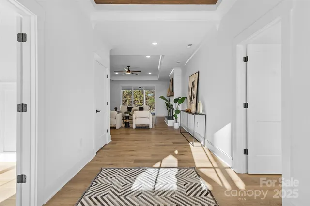 a view of a hallway with wooden floor and a living room