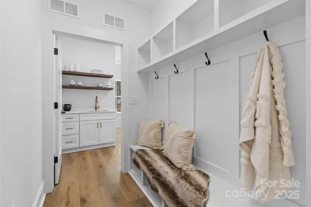 a hallway with white cabinets and wooden floor