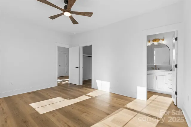 a view of a bedroom with a bed and ceiling fan