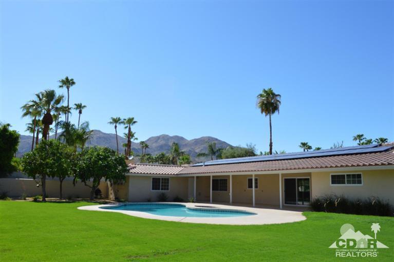 72825 Bel Air Road Palm Desert, CA 92260 - Photo 1 of 23 a front view of a house with a garden and yard