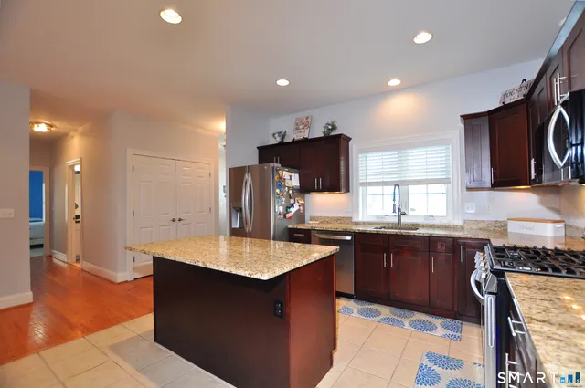 a kitchen with stainless steel appliances granite countertop a sink counter space and cabinets