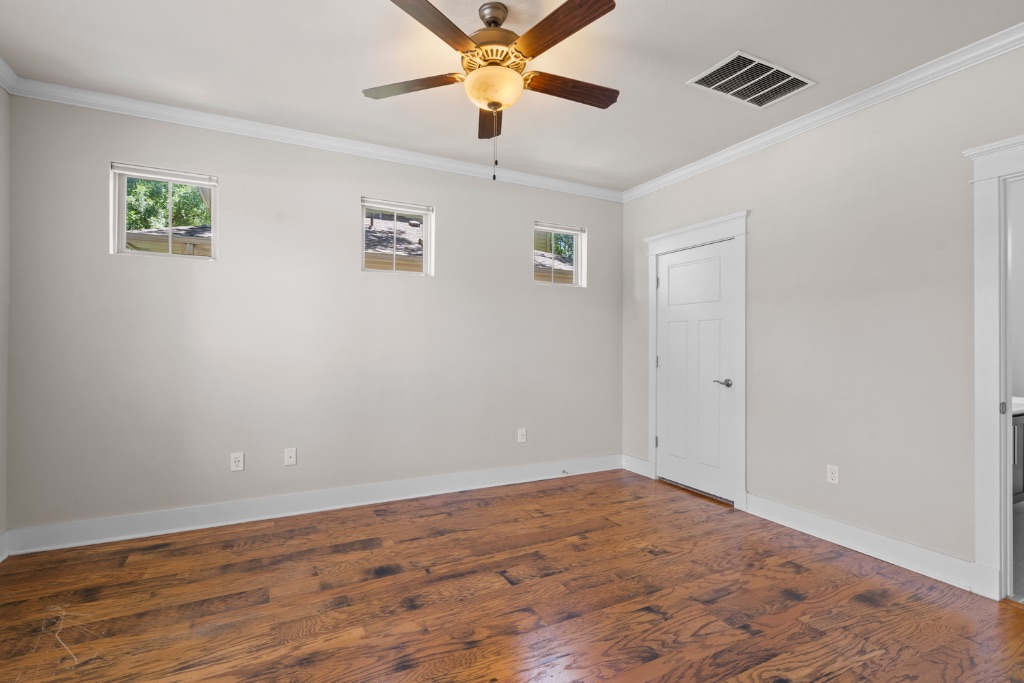 11229 Avery Station Loop, Unit 36 Austin, TX 78717 - Photo 12 of 37 Unfurnished bedroom with dark wood-style flooring, ornamental molding, multiple windows, and a ceiling fan