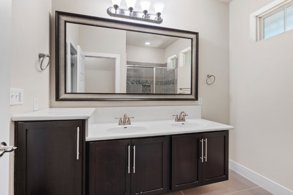 11229 Avery Station Loop, Unit 36 Austin, TX 78717 - Photo 15 of 37 Full bathroom with double vanity, light tile patterned floors, and a shower stall