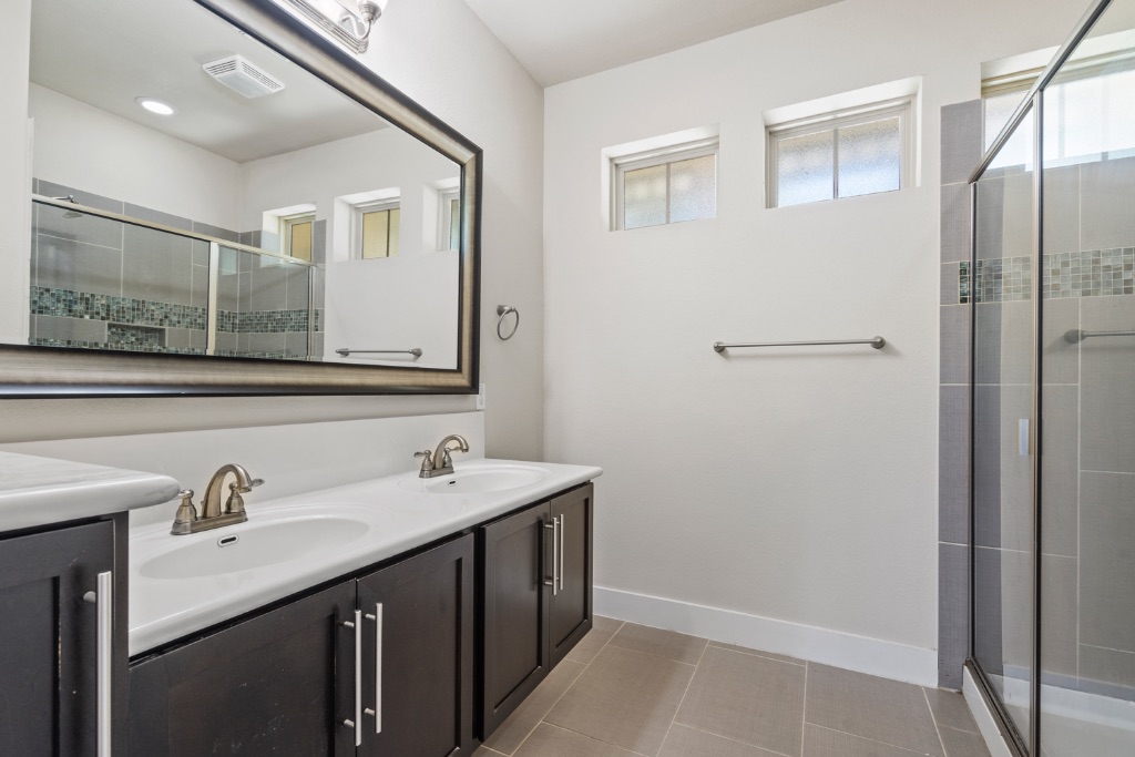 11229 Avery Station Loop, Unit 36 Austin, TX 78717 - Photo 17 of 37 Full bathroom featuring double vanity, a shower stall, and light tile patterned flooring