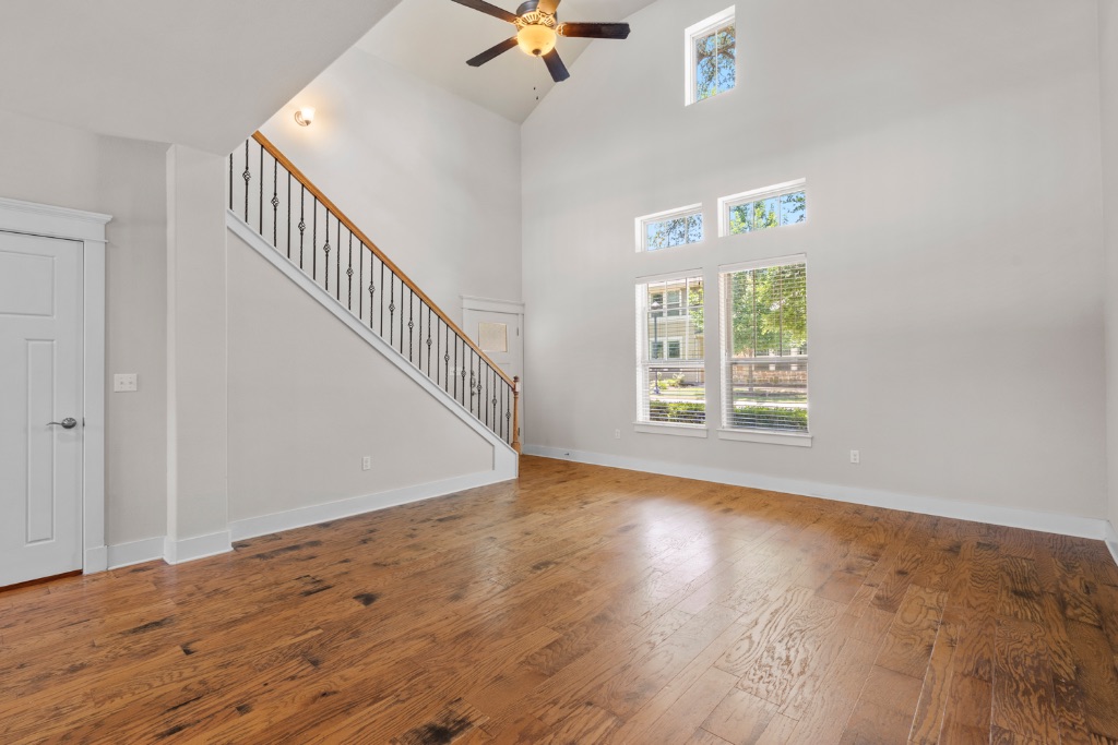 11229 Avery Station Loop, Unit 36 Austin, TX 78717 - Photo 6 of 37 Unfurnished living room with dark wood-style floors, a ceiling fan, and lofted ceiling