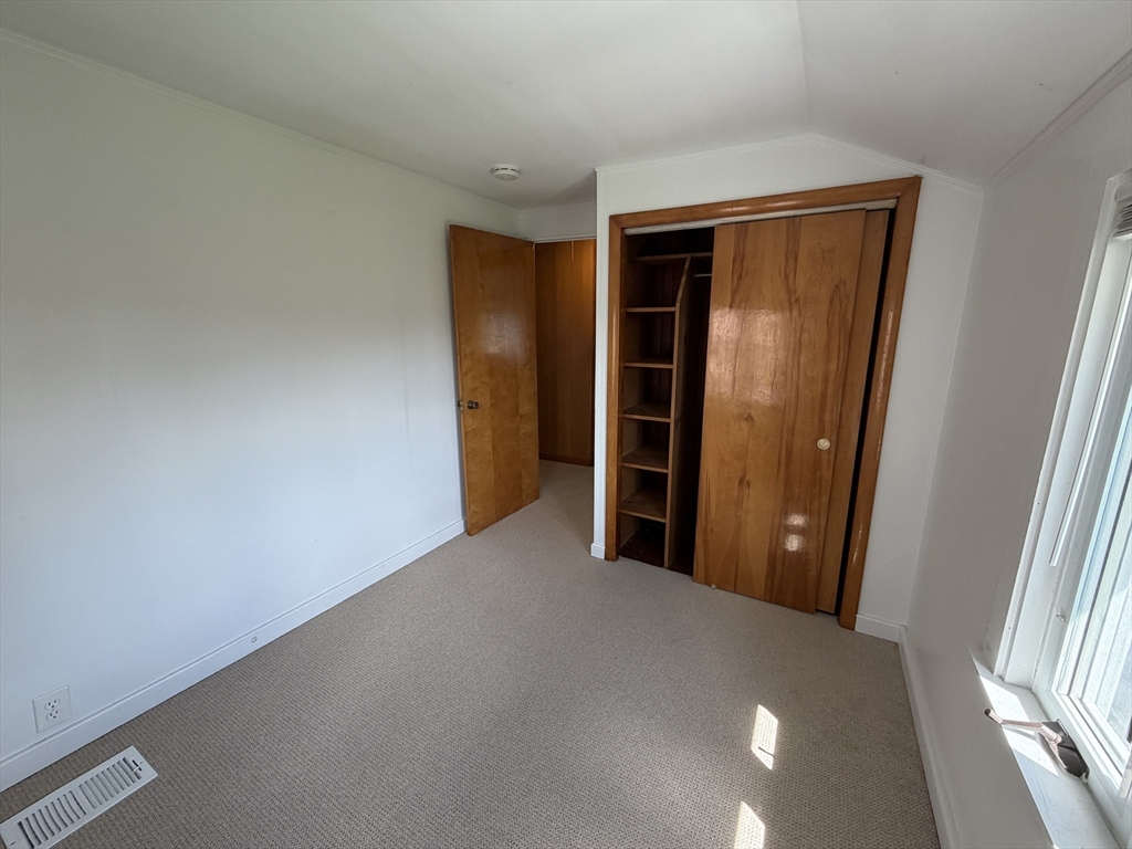175 Spring Street, Unit 1 Hull, MA 02045 - Photo 13 of 15 an empty room with closet and wooden floor