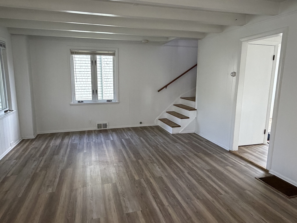 175 Spring Street, Unit 1 Hull, MA 02045 - Photo 2 of 15 a view of an empty room with wooden floor and stairs