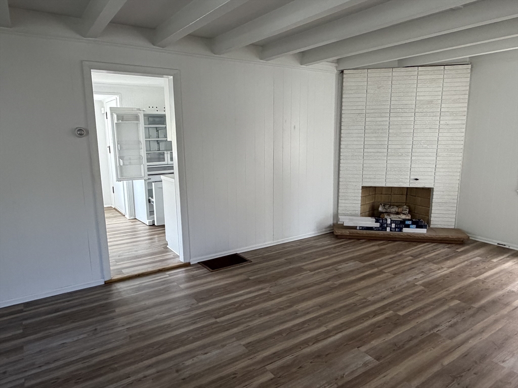 175 Spring Street, Unit 1 Hull, MA 02045 - Photo 3 of 15 a view of empty room with wooden floor and fireplace
