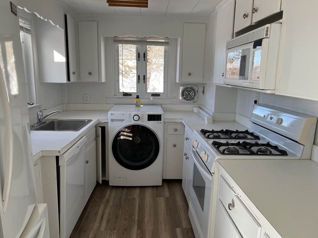 175 Spring Street, Unit 1 Hull, MA 02045 - Photo 4 of 15 a kitchen with a stove top oven sink and cabinets