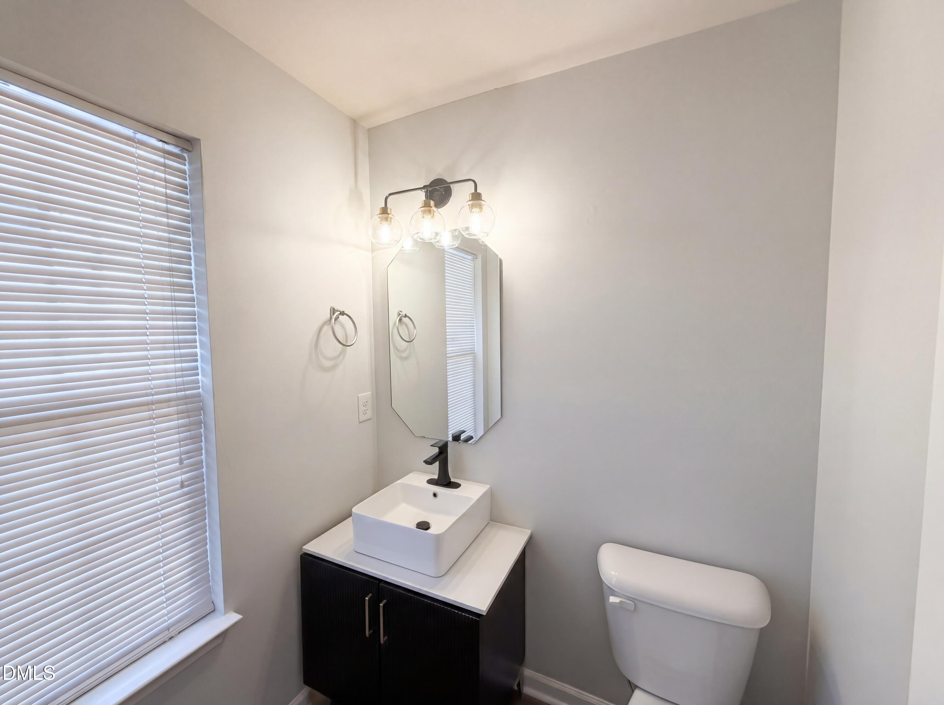 4716 Queen Pierrette Street Raleigh, NC 27610 - Photo 12 of 15 a bathroom with a toilet sink and mirror