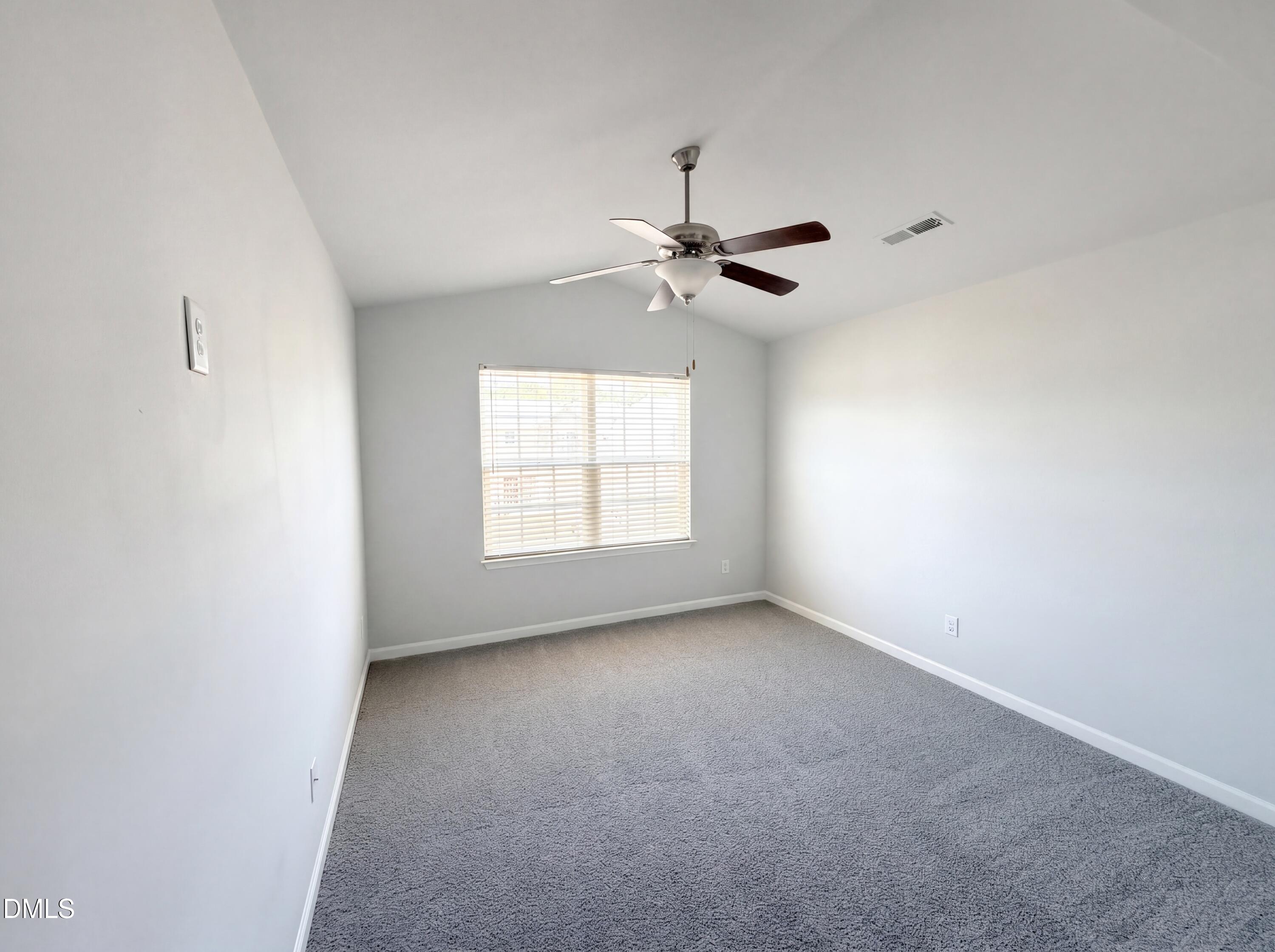 4716 Queen Pierrette Street Raleigh, NC 27610 - Photo 4 of 15 an empty room with a chandelier fan and windows