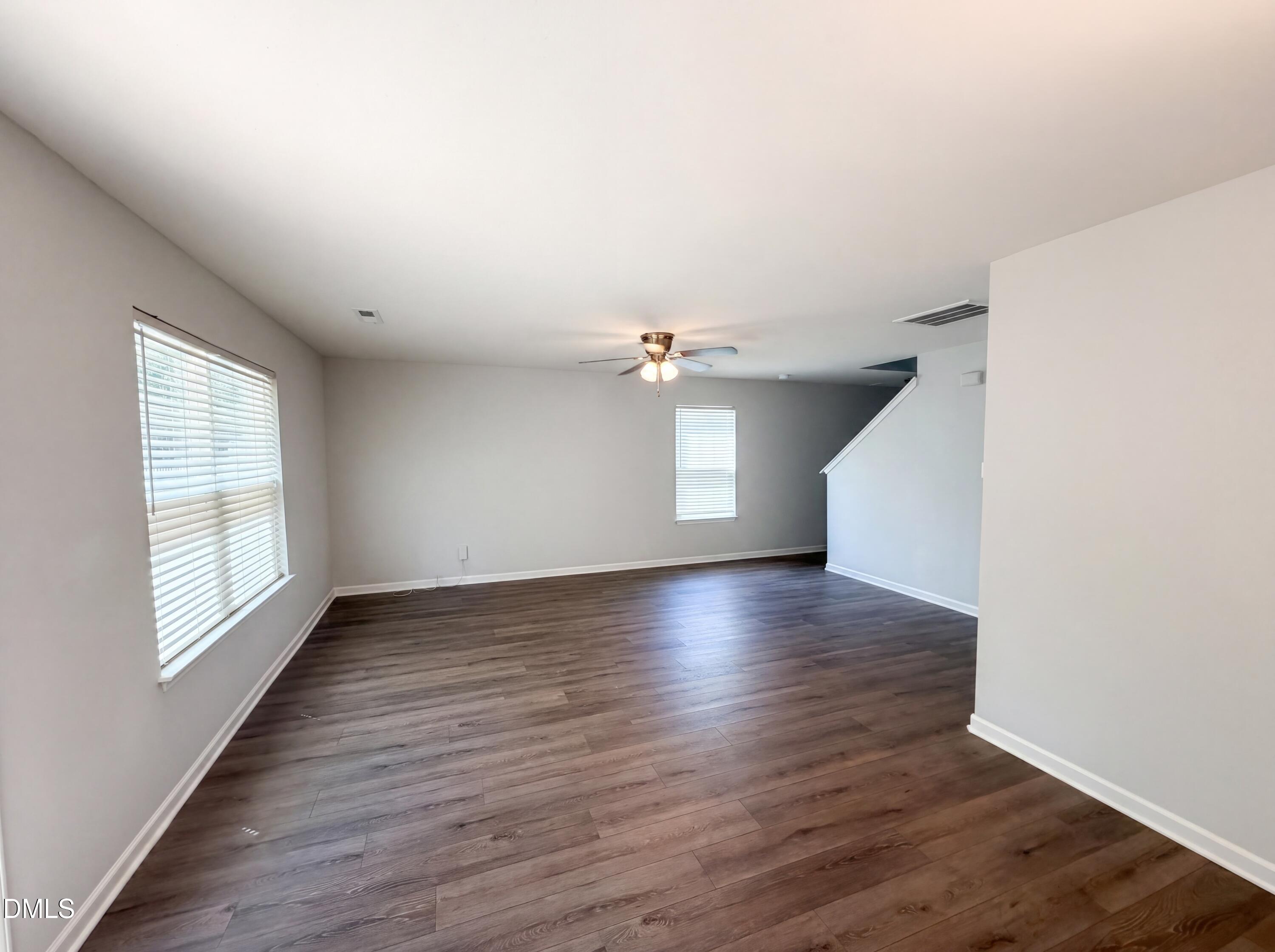 4716 Queen Pierrette Street Raleigh, NC 27610 - Photo 6 of 15 an empty room with wooden floor and windows