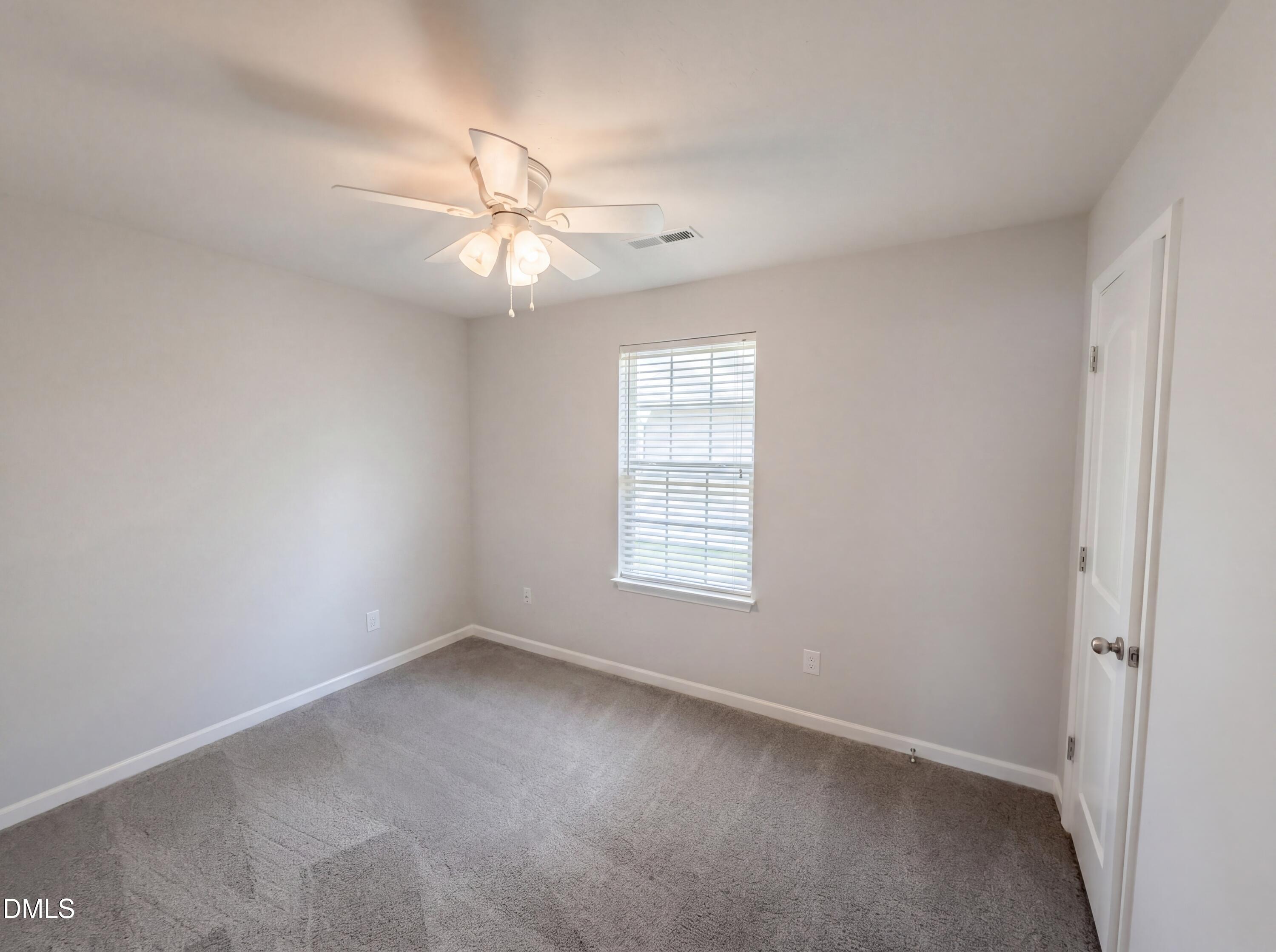 4716 Queen Pierrette Street Raleigh, NC 27610 - Photo 9 of 15 an empty room with a window and a fan