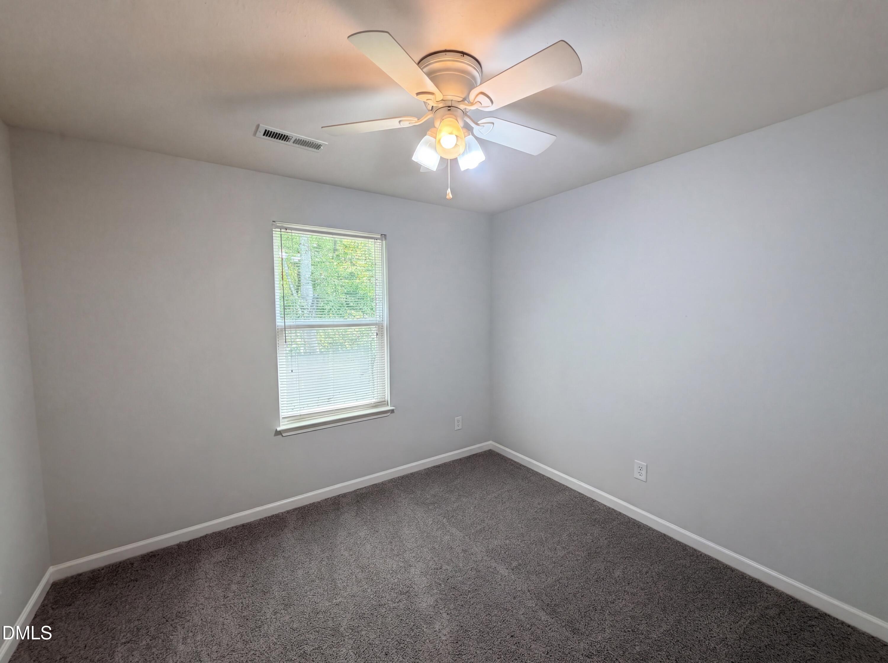 4716 Queen Pierrette Street Raleigh, NC 27610 - Photo 10 of 15 an empty room with a window and a fan