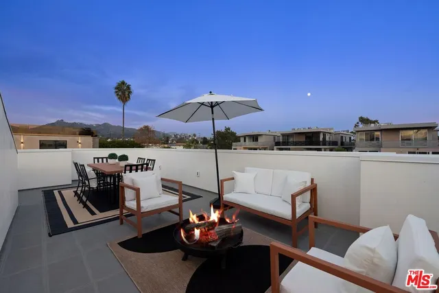 a view of a terrace with furniture and umbrella