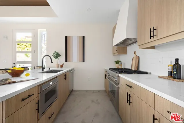 a kitchen with sink a stove and cabinets