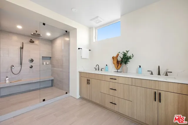 a bathroom with a shower sink and mirror