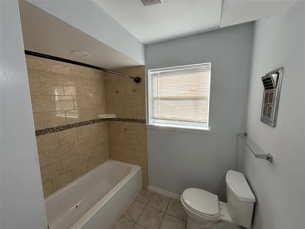 a bathroom with a toilet a bath tub and a shower