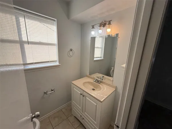 a bathroom with a sink toilet and window