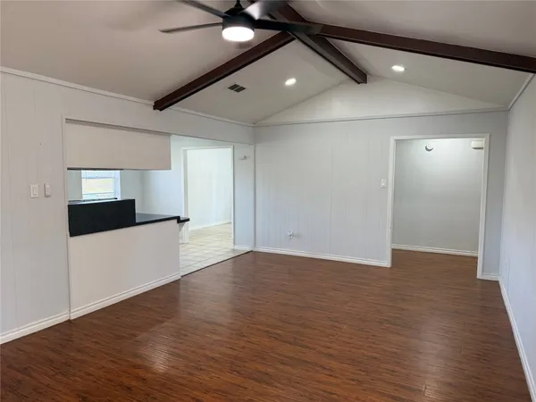 a view of an empty room with wooden floor