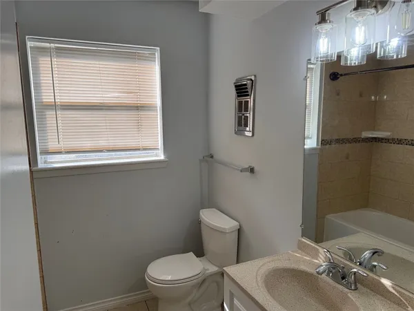 a bathroom with a granite countertop sink toilet a mirror and shower