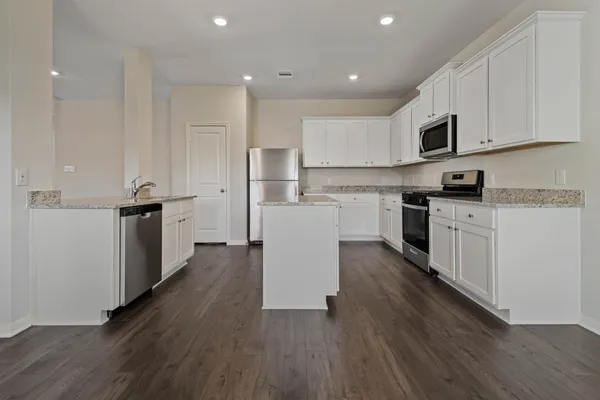a kitchen with a sink a microwave and cabinets