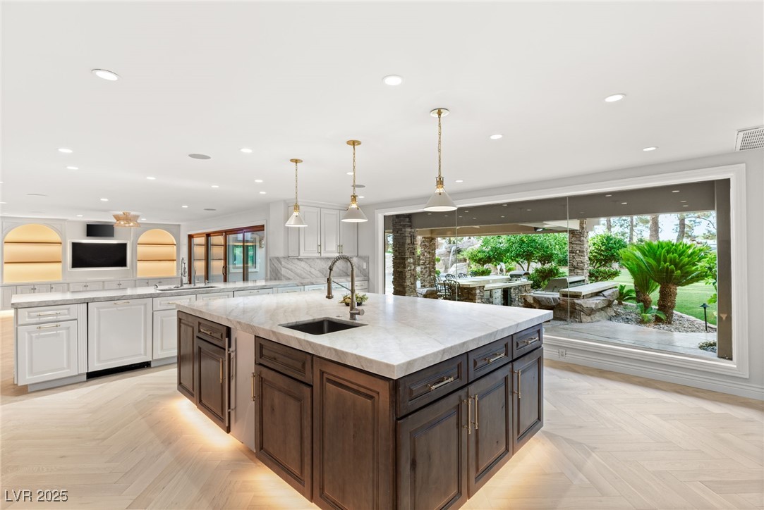 105 Quail Run Road Henderson, NV 89014 - Photo 13 of 88 Kitchen featuring white cabinetry, a kitchen islan