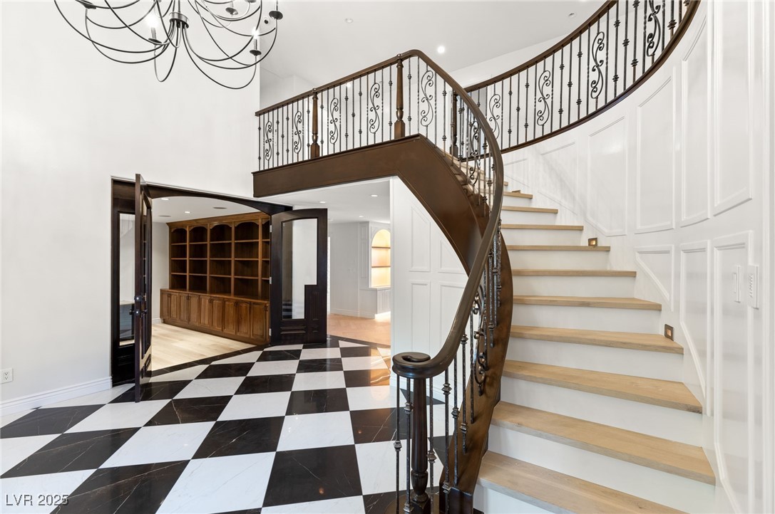 105 Quail Run Road Henderson, NV 89014 - Photo 38 of 88 Staircase with a chandelier and a high ceiling