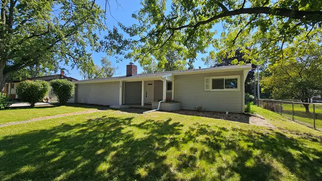 a backyard of a house with table and chairs