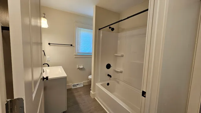 a bathroom with a tub shower vanity and a sink