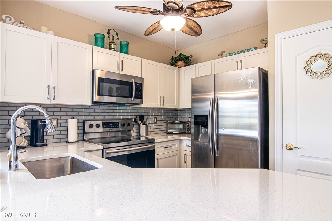 11753 Eros Road Lehigh Acres, FL 33971 - Photo 5 of 34 a kitchen with a refrigerator sink and microwave