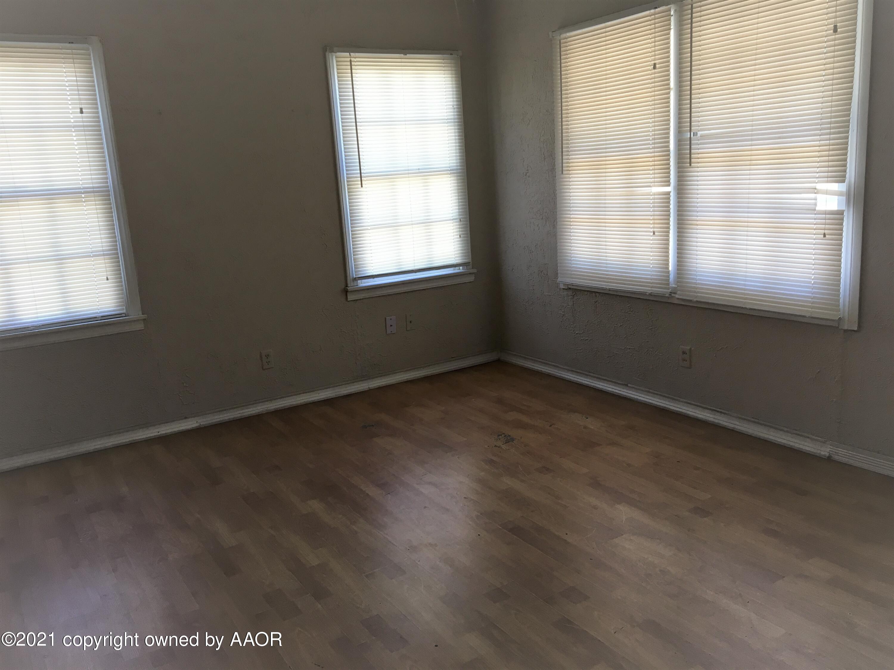 3618 South Travis Street Amarillo, TX 79110 - Photo 3 of 7 an empty room with wooden floor and windows