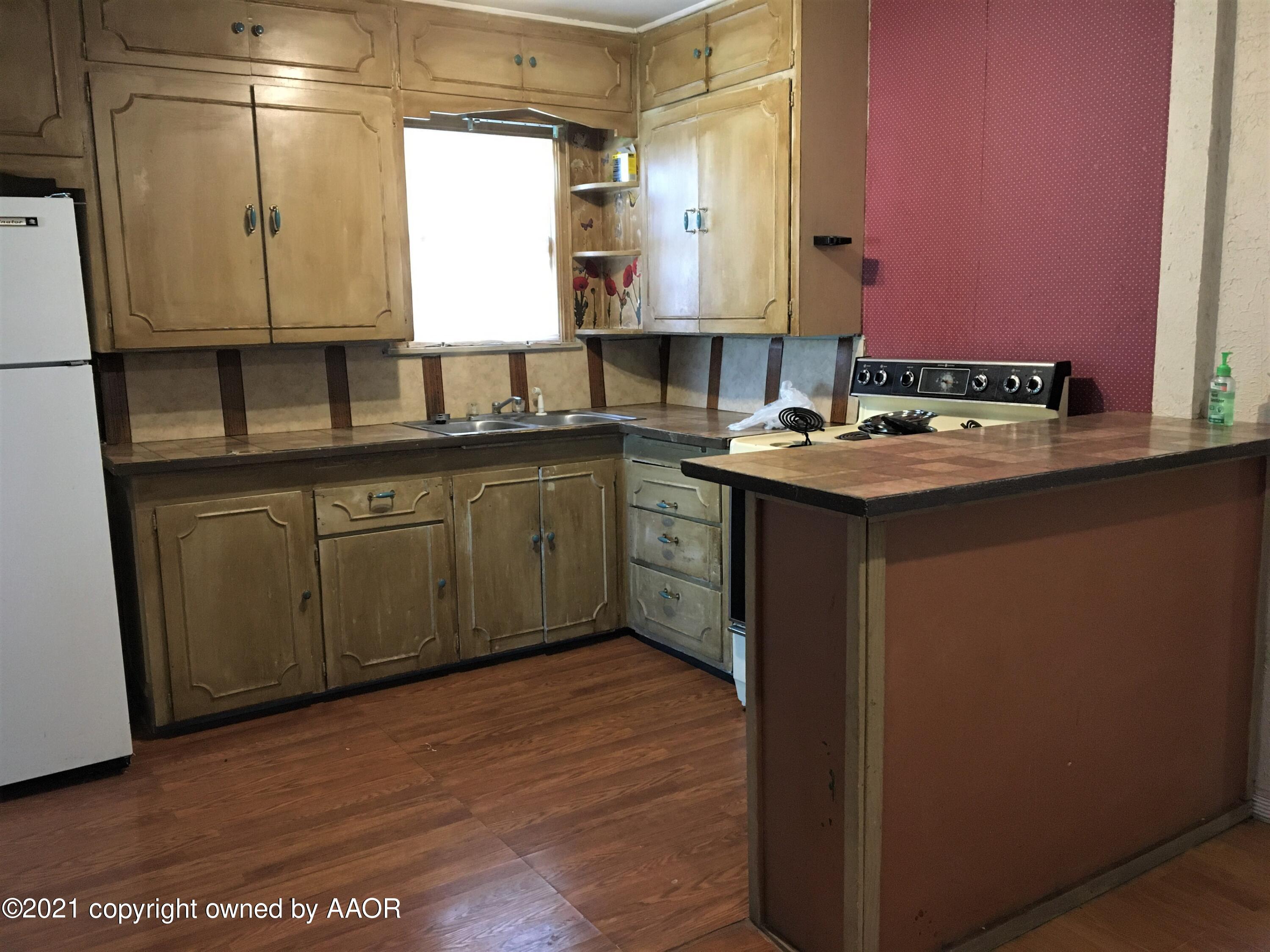 3618 South Travis Street Amarillo, TX 79110 - Photo 5 of 7 a kitchen with a sink cabinets and wooden floor