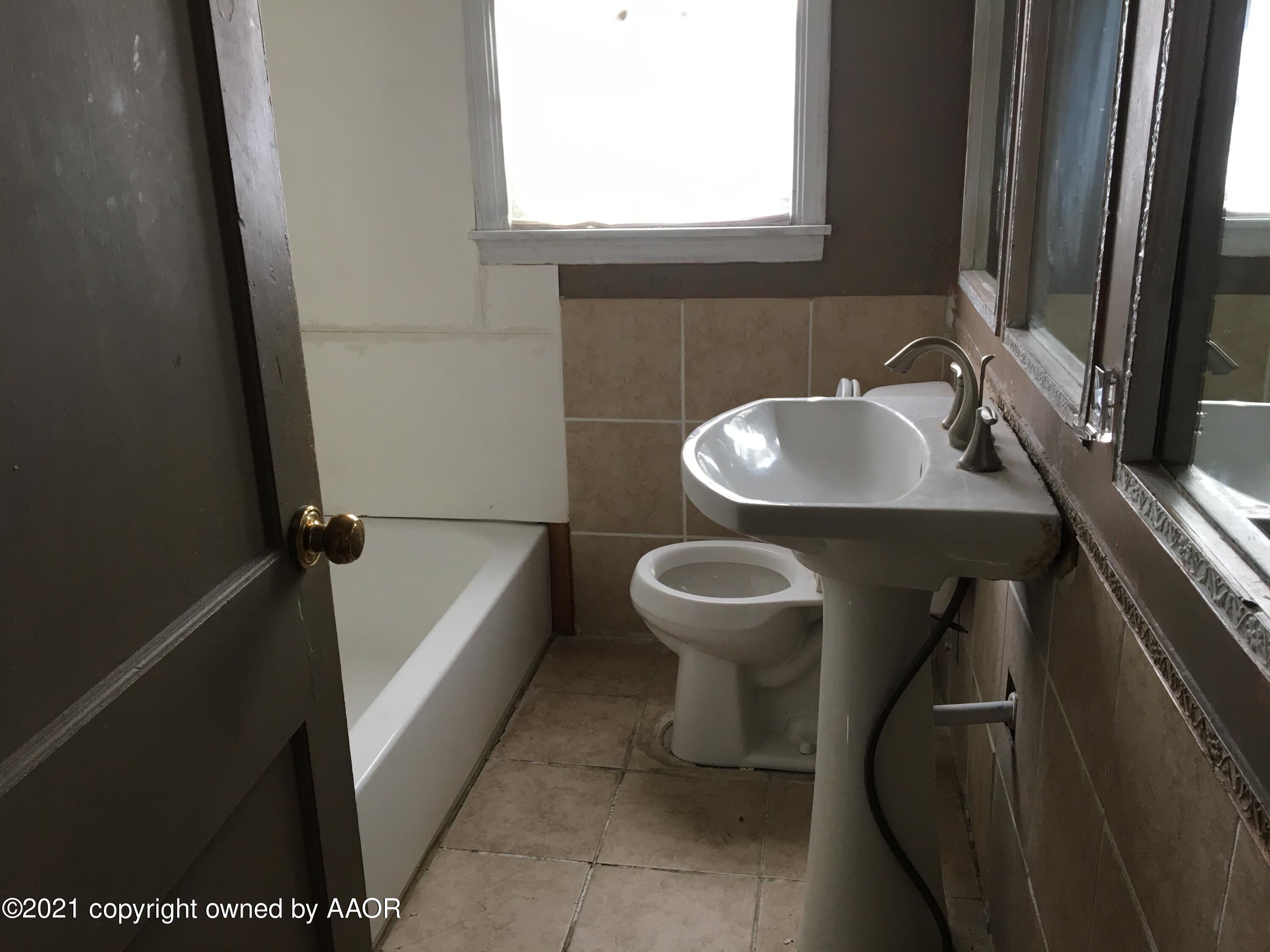 3618 South Travis Street Amarillo, TX 79110 - Photo 7 of 7 a bathroom with a sink a toilet and bathtub