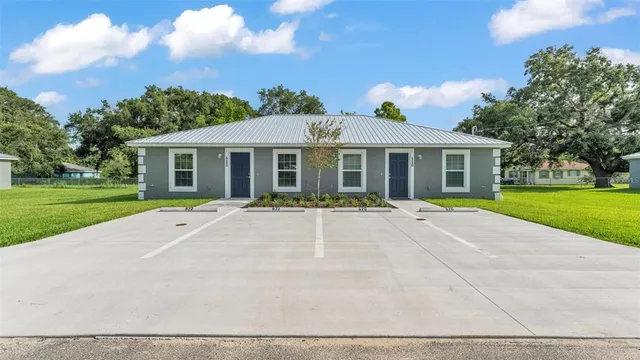 a view of a house with a swimming pool and a yard