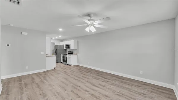 a view of a kitchen with wooden floor and a ceiling fan